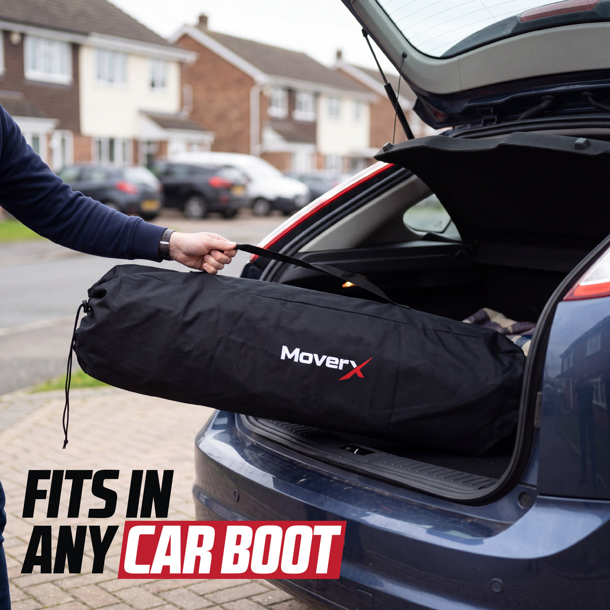 MoverX foldable camping chair in its black carrying bag being placed in a blue car boot.